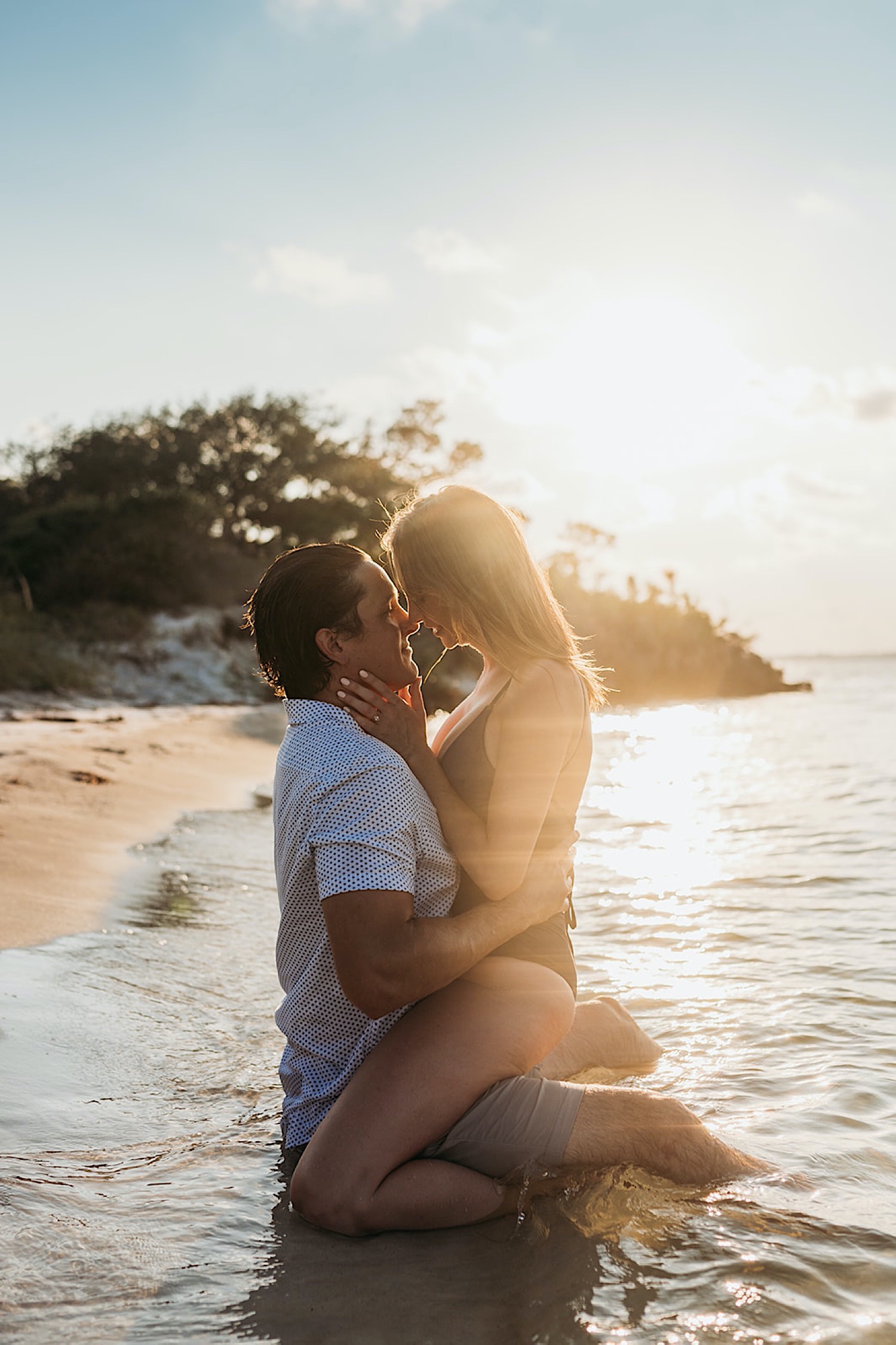 Secluded beach engagement photos with couple in the water