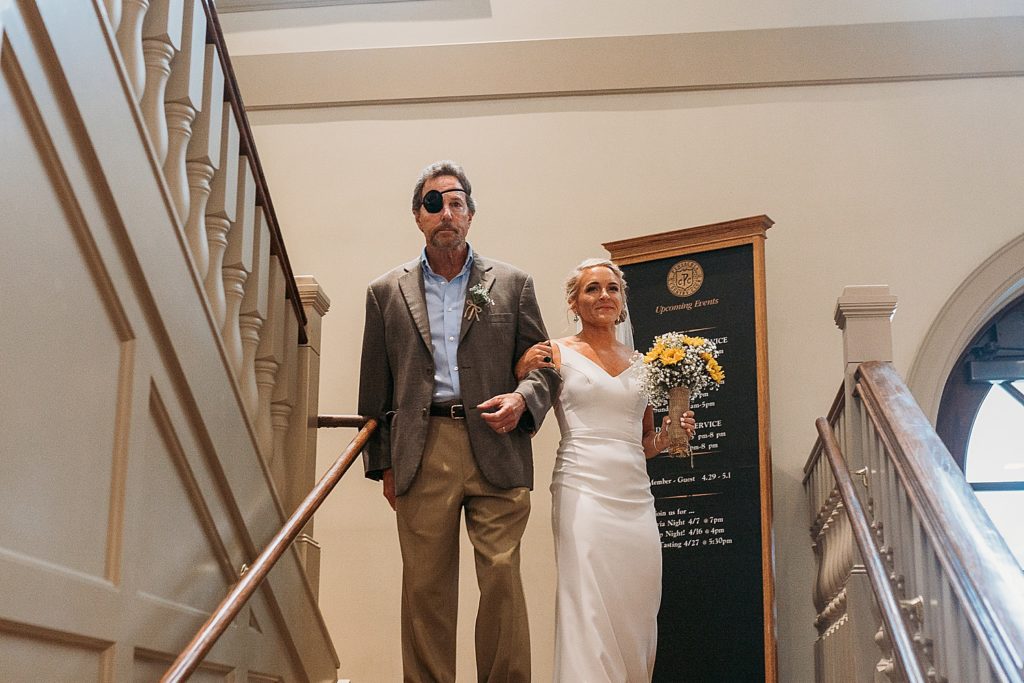 bride and father walk down the aisle together at pensacola country club 