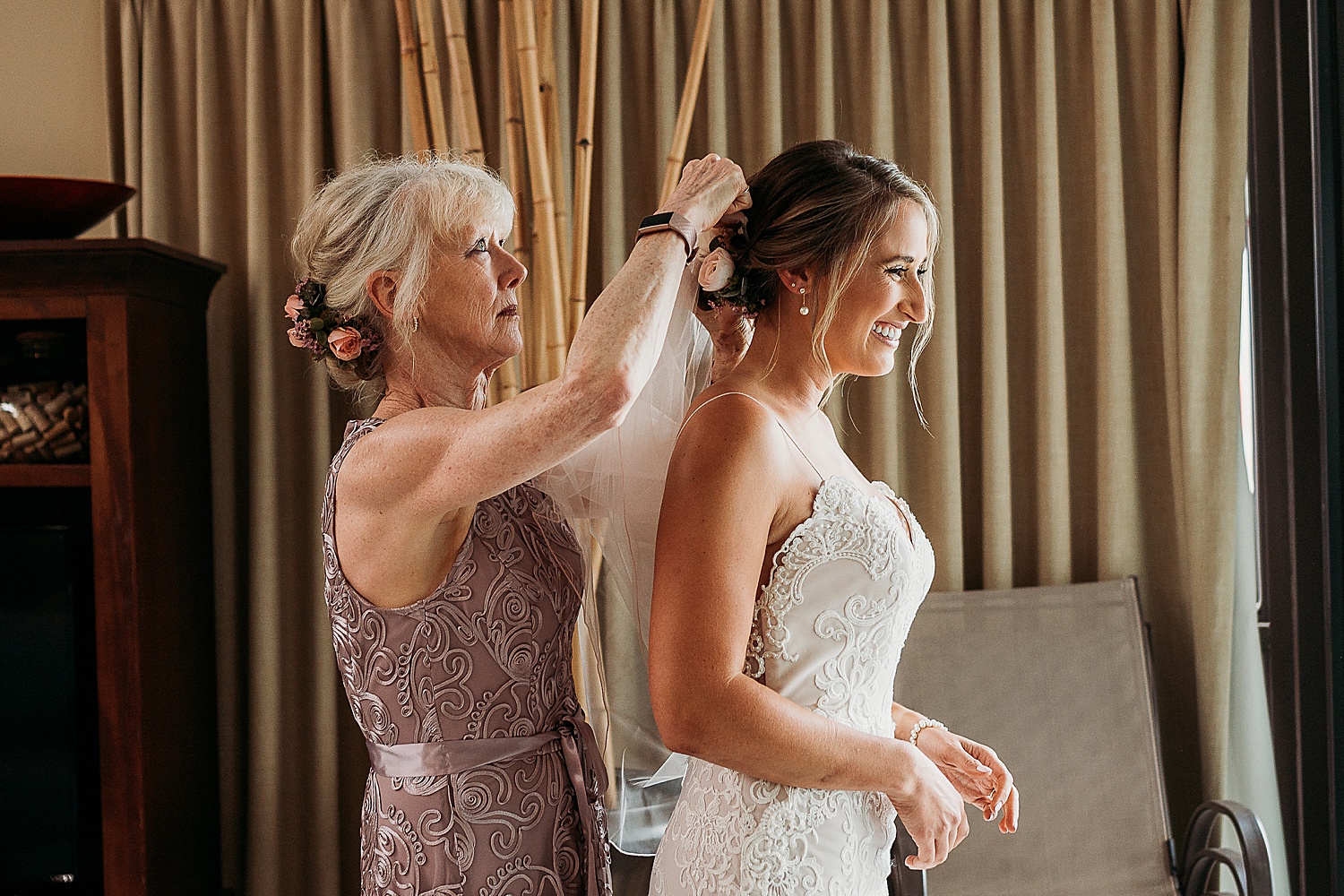 mother of bride putting veil in daughters hair before ceremony at Mainsail Resort 