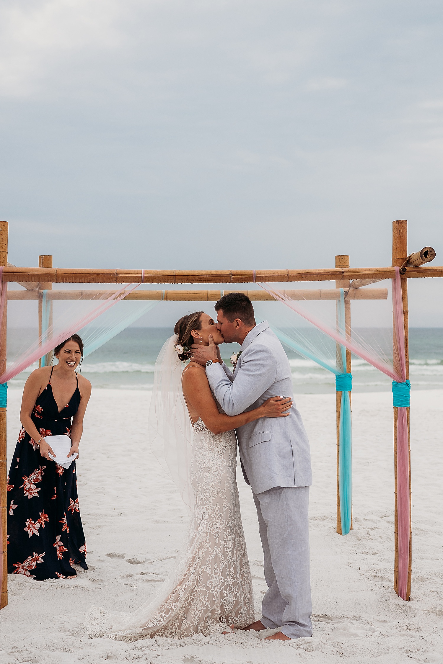 bride and groom share first kiss at mainsail resort in front of friends and family