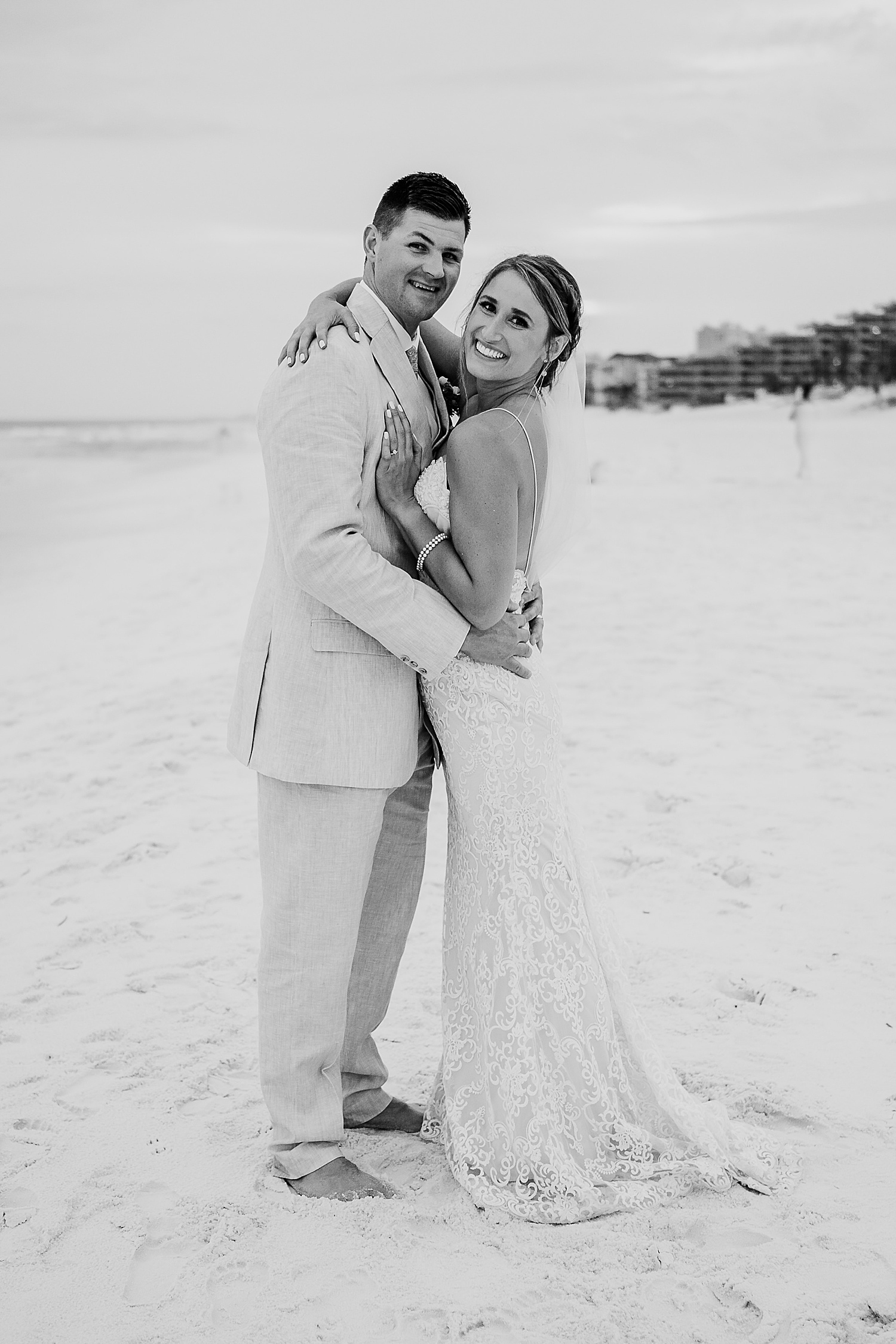bride and groom smile at Destin wedding photographer on Florida beach at sunset 