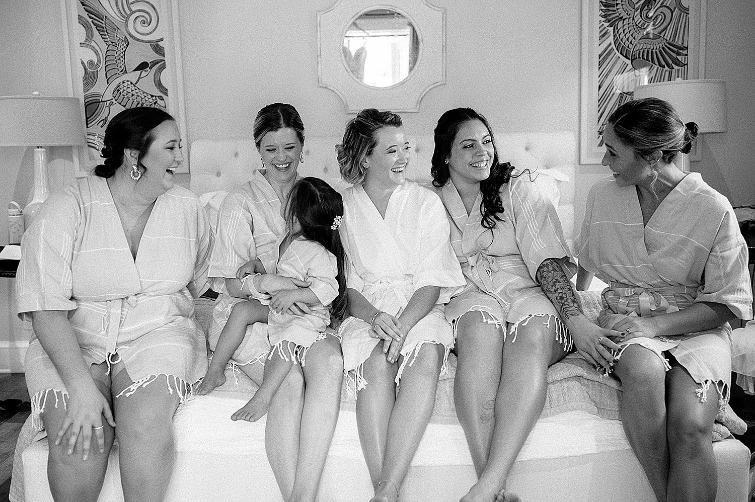 bridesmaids wearing robes with bride and flower girl
