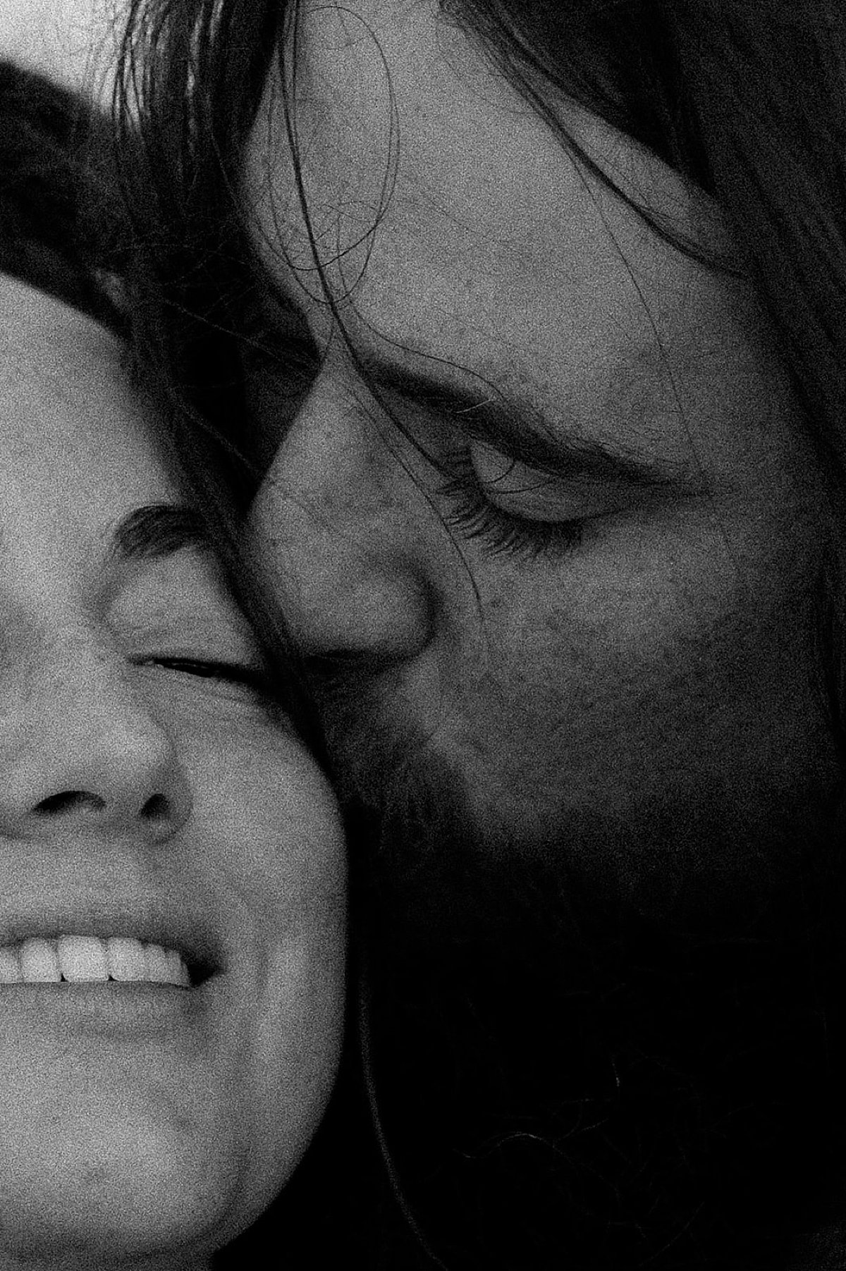 cheek kisses on the beach in Florida with man and woman couple with long hair 