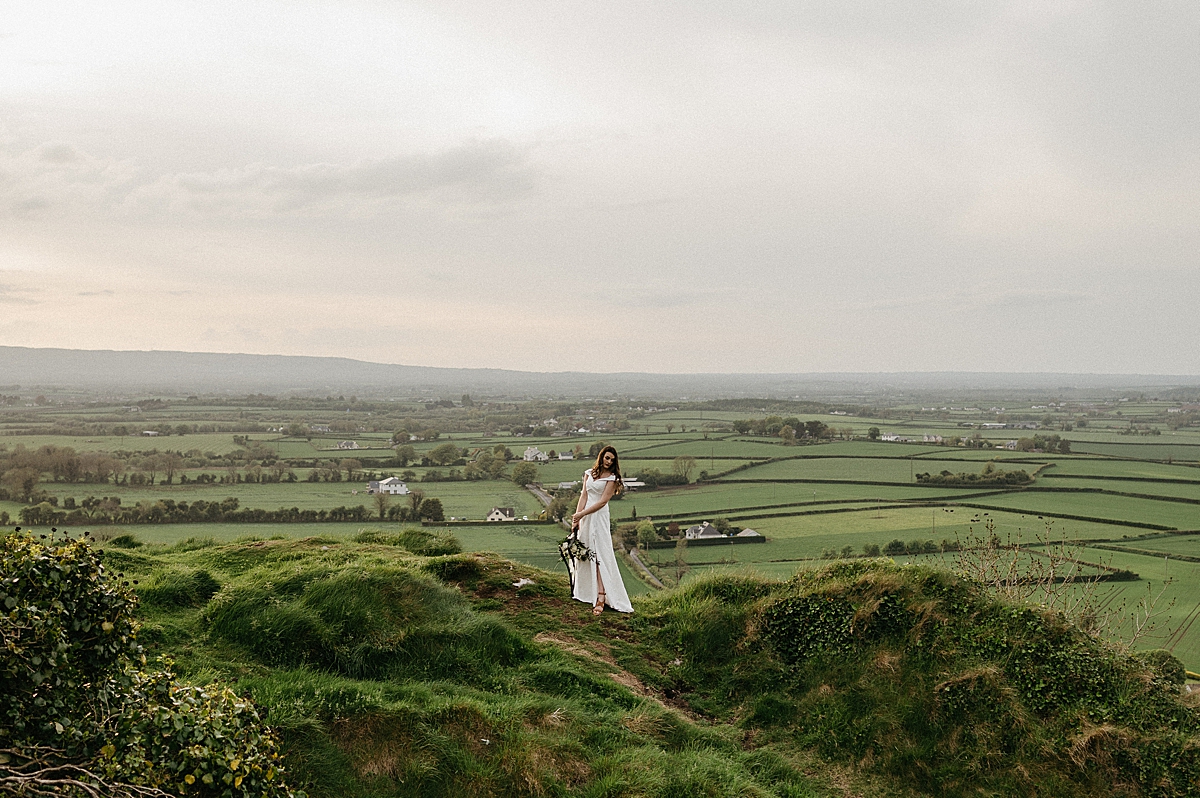solo portrait of bride overlooking the Ireland hills by Emily burns photography
